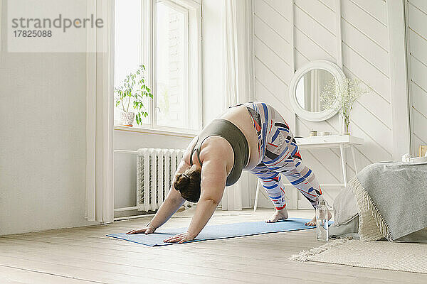 Frau praktiziert Yoga zu Hause