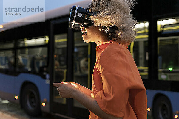 Frau genießt es  nachts im Bus ein Virtual-Reality-Headset zu tragen