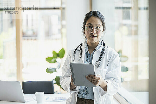 Lächelnde Ärztin mit Tablet-PC im Büro