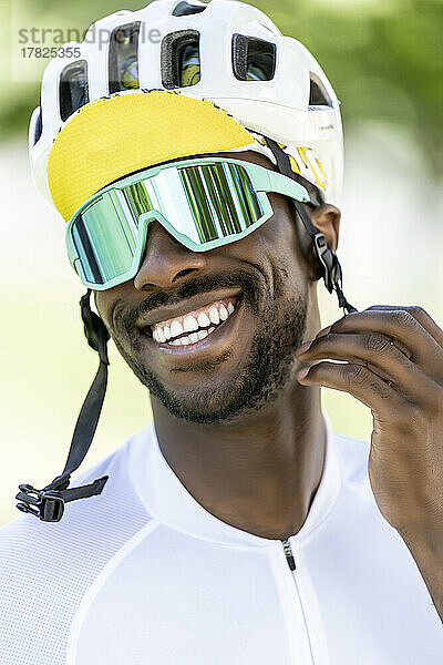 Glücklicher Radfahrer mit Fahrradhelm und Sonnenbrille