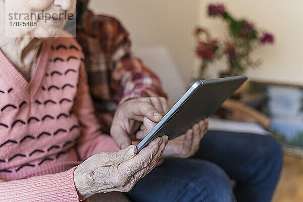 Reifer Mann bringt Seniorin zu Hause Tablet-PC bei