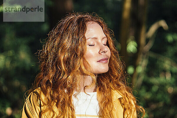 Redhead young woman enjoying sunlight