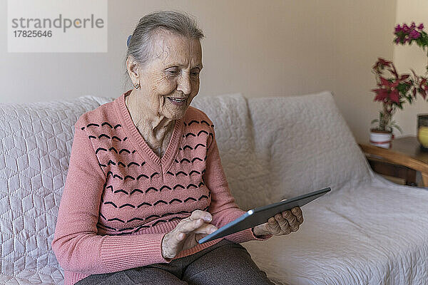 Ältere Frau nutzt Tablet-PC zu Hause