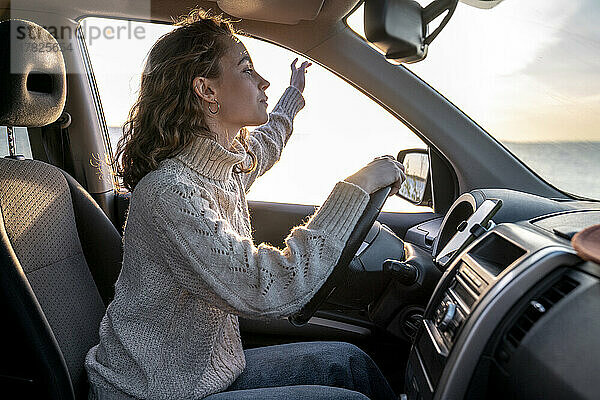 Junge Frau sitzt auf dem Fahrersitz im Auto