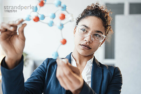 Geschäftsfrau untersucht molekulare Struktur im Büro