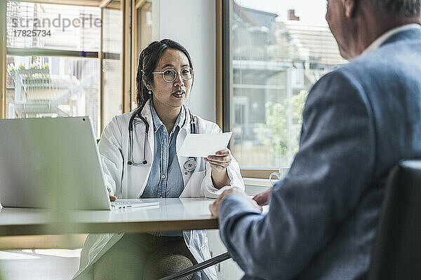 Doctor discussing with patient over prescription in medical clinic