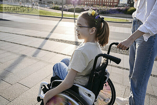 Frau mit Mädchen im Rollstuhl im Park an einem sonnigen Tag