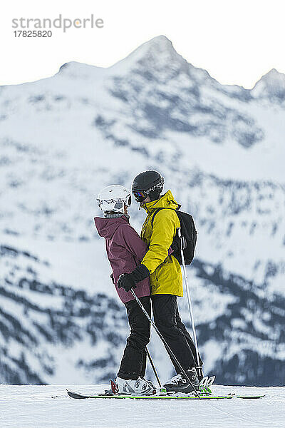 Romantisches Paar in Skikleidung umarmt sich im Baqueira Beret Resort  Pyrenäen  Spanien