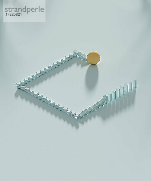 Studio shot of yellow sphere knocking down domino pieces organized in square shape