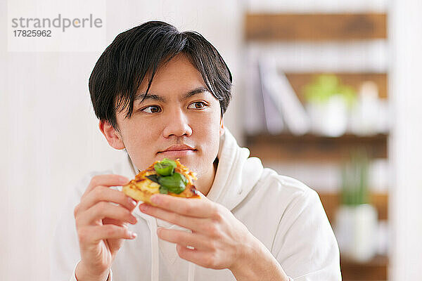 Junger Japaner genießt eine Mahlzeit