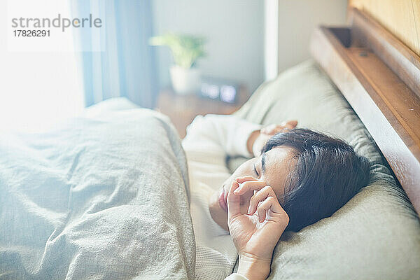 Japanischer Mann morgens im Bett