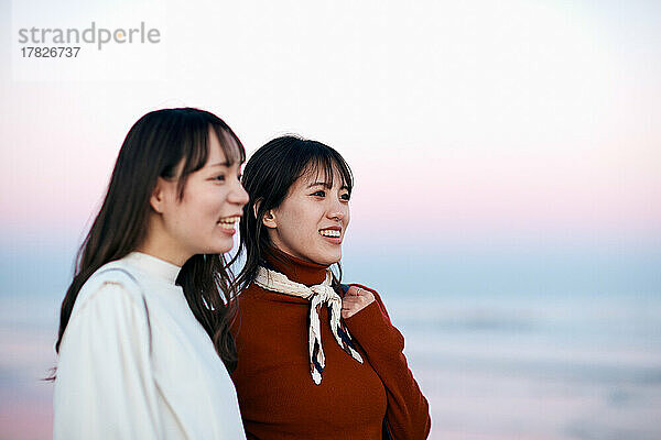 Junge japanische Frauen amüsieren sich am Strand