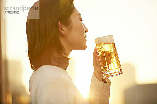 Japanerin trinkt draußen etwas