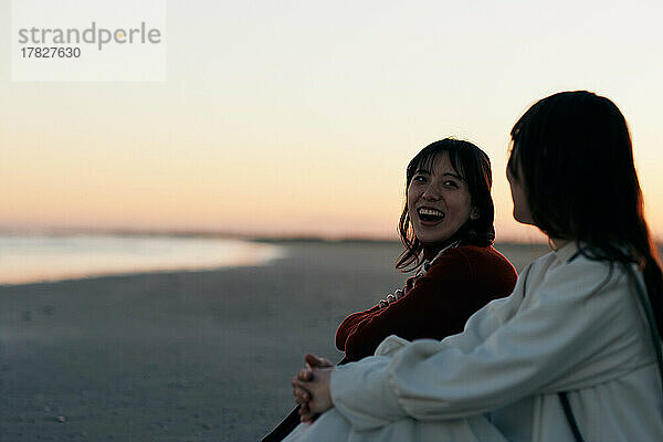 Junge japanische Frauen amüsieren sich am Strand