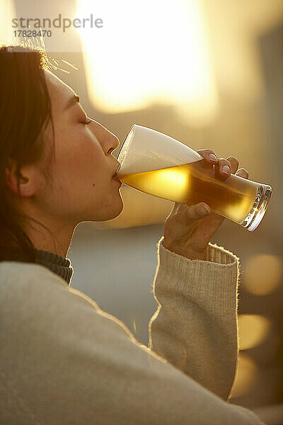 Japanerin trinkt draußen etwas