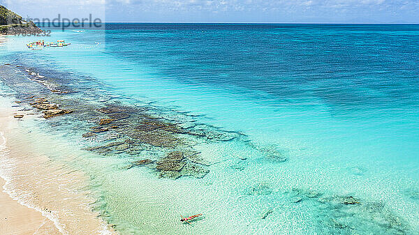 Frau schwimmt im kristallklaren Meer an einem idyllischen tropischen Strand  Blick von oben  Antigua  Leeward Islands  Westindien  Karibik  Mittelamerika