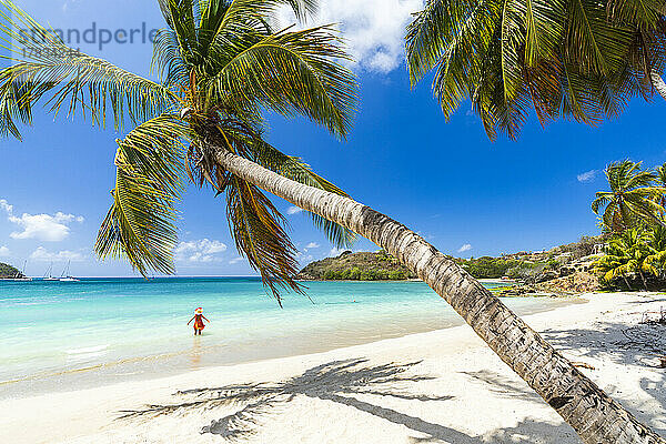 Fröhliche Frau beim Sonnenbaden im kristallklaren karibischen Meer  Antigua  Leeward Islands  Westindien  Karibik  Mittelamerika