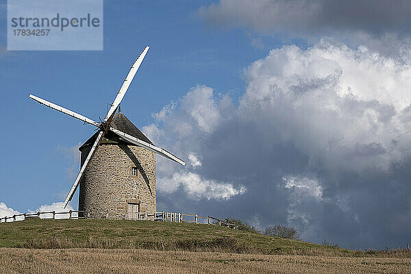 Windmühle auf einem Hügel mit blauem Himmel mit weißen Wolken  Normandie  Frankreich  Europa