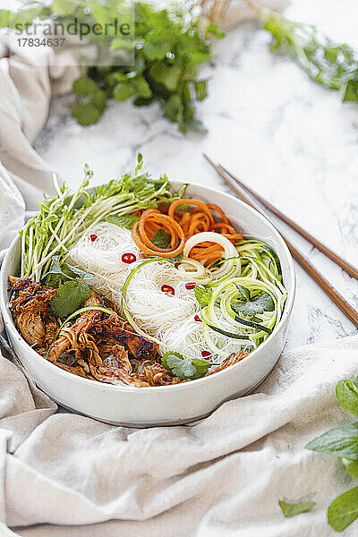 Chicken Noodle Bowl mit Zucchini  geraspelter Karotte und frischen Kräutern