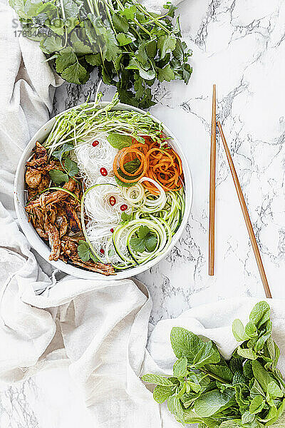 Chicken Noodle Bowl mit Zucchini  geraspelter Karotte und frischen Kräutern