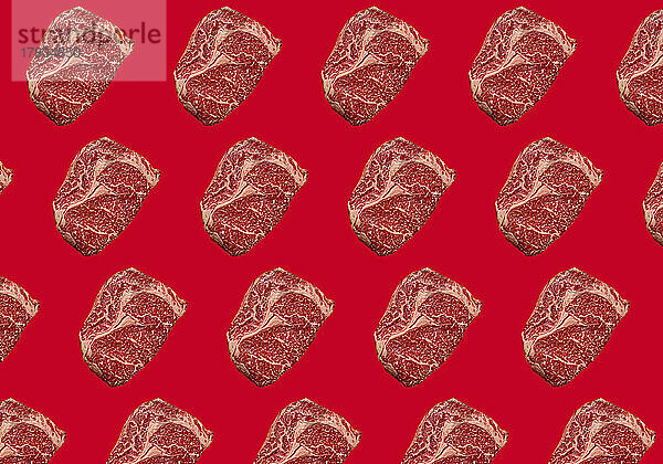 Rohe Ribeye-Steaks auf rotem Hintergrund