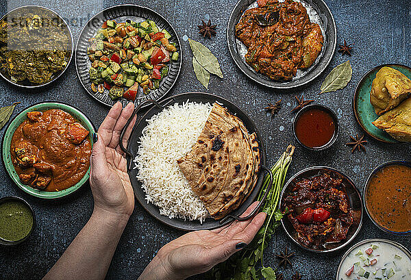 Hände servieren indische Gerichte