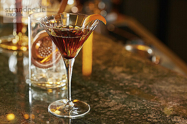Whiskey-Cocktail im Martiniglas  garniert mit Orange