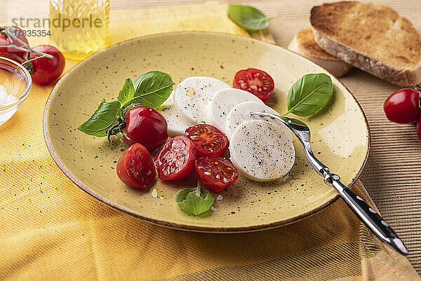 Veganer 'Mozzarella' mit Olivenöl  Tomaten und Basilikum