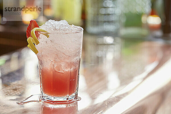 Roter Cocktail mit Crushed Ice  Erdbeer- und Zitronengarnierung