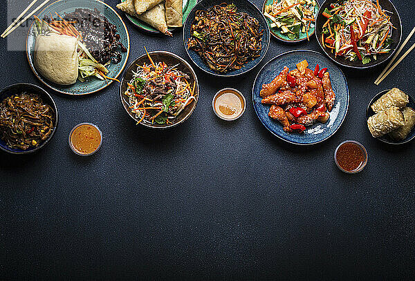 Verschiedene chinesische Gerichte auf dunklem Untergrund