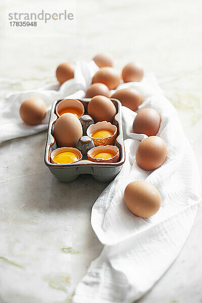 Ganze und aufgeschlagene Eier im Eierkarton