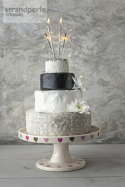 Cheese Wedding Cake - Käsesorten als mehrstöckige Hochzeitstorte arrangiert  mit Wunderkerzen und Blüten