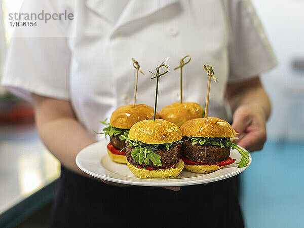 Kellner serviert vier Mini-Veggie-Burger