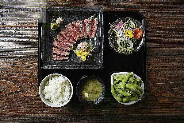Japanische Mittagsgericht mit Rindfleisch  Reis  Misosuppe  Edamame und Salat