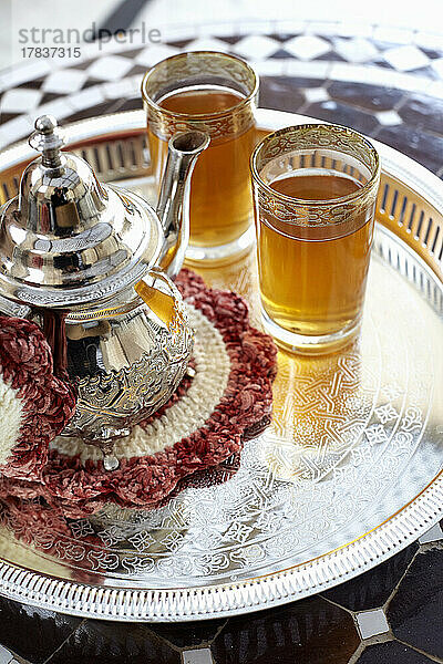 Teekanne und zwei Gläser orientalischer Tee auf Silbertablett