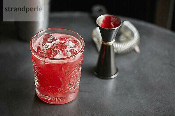 Roter Cocktail in einem Glas mit Eiswürfeln