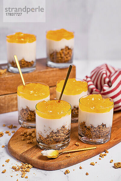 Joghurtdessert mit Müsli und Orangen-Mango-Mousse in Gläsern