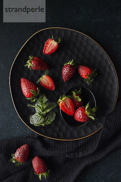 Frische Erdbeeren auf schwarzem Teller