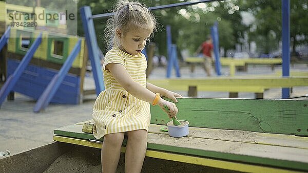 Nettes kleines Mädchen spielt im Sandkasten auf dem Spielplatz. Kind Mädchen spielt auf dem Spielplatz im Stadtpark. Odessa  Ukraine  Europa