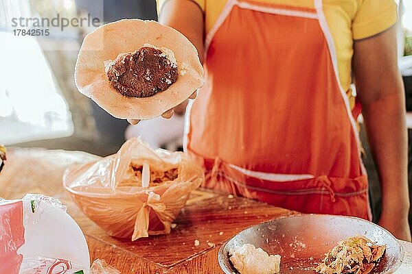 Hände eines Verkäufers  der den Prozess der Herstellung der traditionellen Pupusa zeigt. Herstellung von traditionellen Pupusas  Zubereitung des Teigs für traditionelle nicaraguanische Pupusas