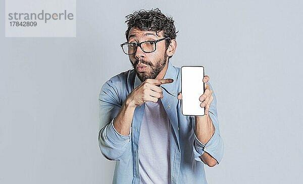 Erstaunter Mann zeigt Handy-Bildschirm  Schockierte Person zeigt und zeigt auf sein Smartphone-Bildschirm  Erstaunte Menschen zeigen und zeigen auf leeren Handy-Bildschirm