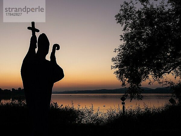 Silhouette der Steinstatue des heiligen Pirmin nach Sonnenuntergang  Insel Reichenau  Bodensee  Baden-Württemberg  Deutschland  Europa