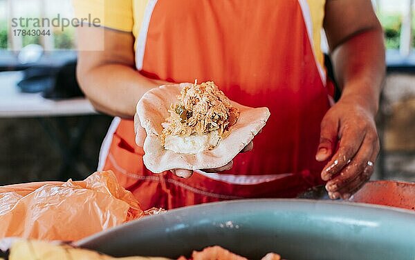 Herstellung traditioneller Pupusas  Herstellung des Teigs für traditionelle Pupusas  Hände der Verkäuferin  die rohe Pupusa zeigt