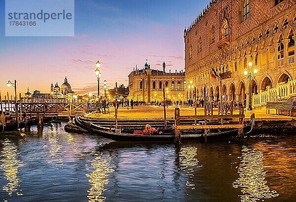 Dogenpalast an der Wasserfront mit Gondel nach Sonnenuntergang bei Abenddämmerung  Venedig  Venetien  Adria  Norditalien  Italien  Europa