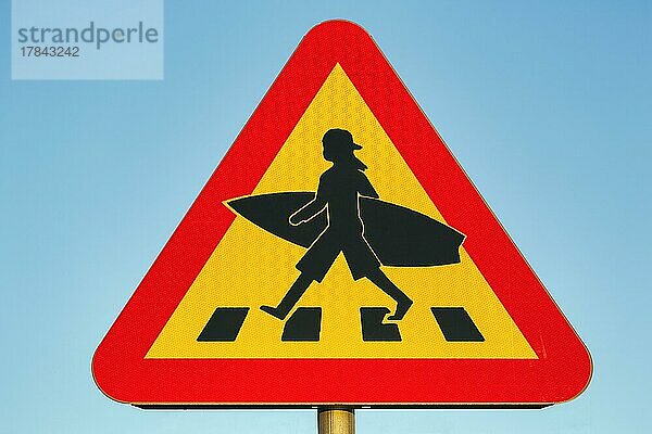 Dreieckiges Verkehrsschild  Vorsicht Surfer  Kind mit Basecap und Surfbrett überquert Zebrastreifen  Lommabukten  Lommabucht  Öresund  Schonen  Schweden  Europa