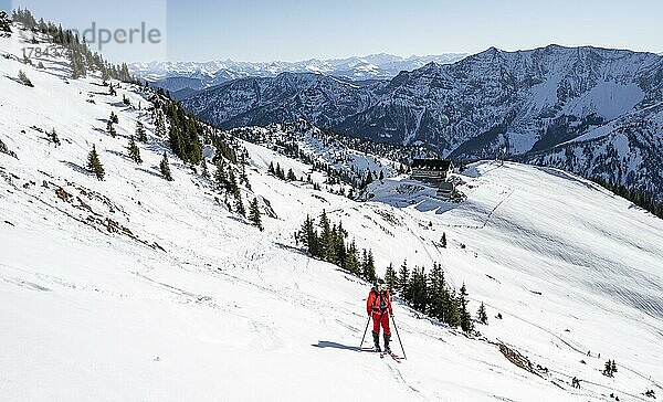 Skitourengeher bei Skitour auf die Rotwand  hinten Berghütte Rotwandhaus mit Bergpanorama  im Winter  Mangfallgebirge  Bayern  Deutschland  Europa