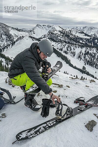 Skitourengeher  Mann baut sein Splitboard zusammen  Winter  Bayern  Deutschland  Europa