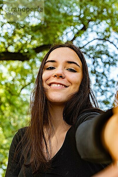 Ein schönes Mädchen macht ein Selfie lächelnd in die Kamera