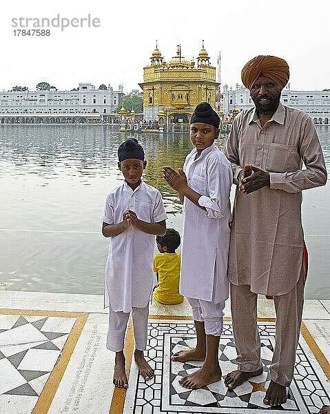 Indische Sikhs in weißen Anzügen und barfuß am Hari Mandir oder Goldenen Tempel  Amritsar  Punjab  Indien  Asien