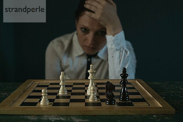 Symbolbild  Verzweiflung  Erfolg  Verwirrung  Strategie  Frau mit einem Schachspiel